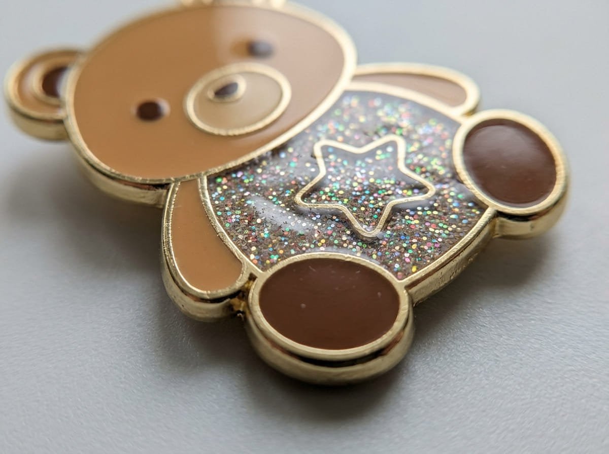 Challenges of glitter finish in enamel pins